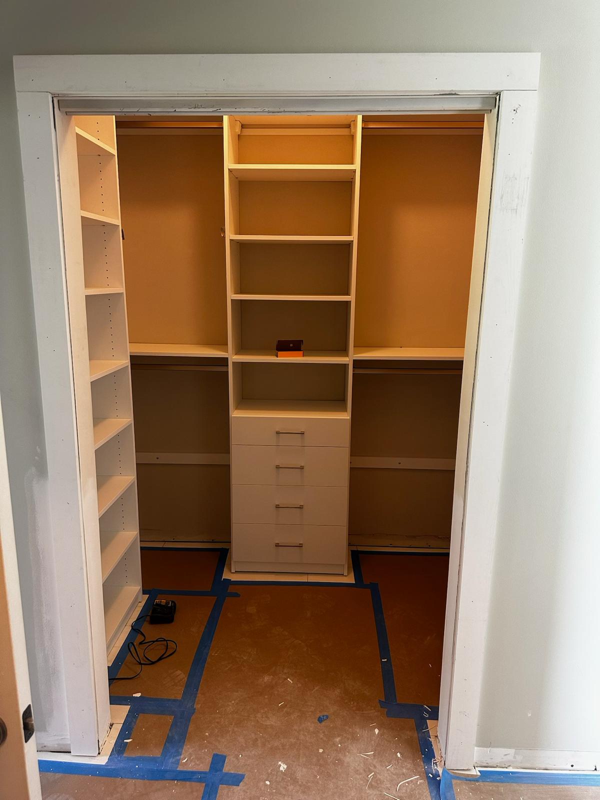 Custom closet build with shelves, drawers, hanging space, and trim work