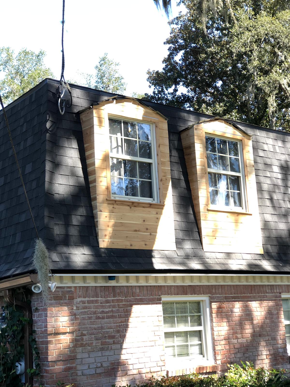 Finished exterior dormers with new natural wood cladding and window trim
