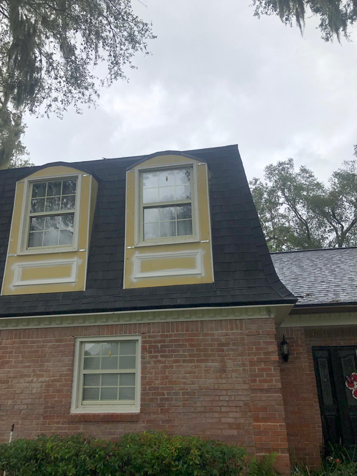 Exterior dormers before repair with visible prep areas around the windows
